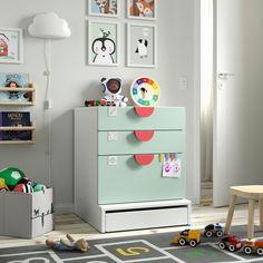 a child's room with toys and pictures on the wall, including a dresser