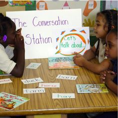 three children sitting at a table with signs in front of them that read the conversation station