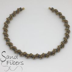 a beaded necklace is shown on a white background with the words sand fibers written below it