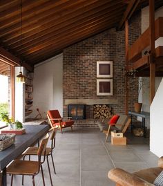 a long table with chairs and a fire place in the middle of a living room