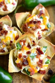 small shells filled with bacon, cheese and green peppers on a wooden table next to pepperoni