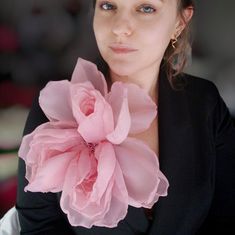 a woman holding a pink flower in her hand