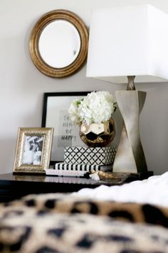 a black table topped with a vase filled with white flowers next to a framed photo