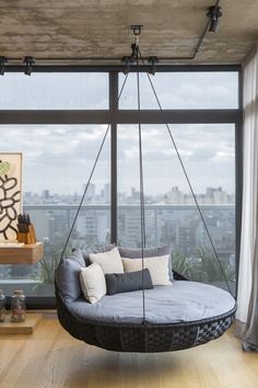 a living room with a large window and a swing chair in the middle of it