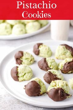 chocolate covered cookies on a white plate next to a glass of milk