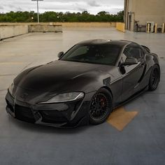 a black sports car parked in a parking lot