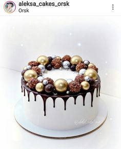 a white cake with chocolate and gold decorations