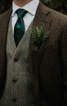 a man wearing a suit and tie with a boutonniere on his lapel