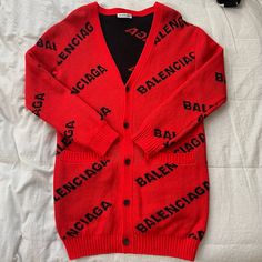 Balenciaga Wool-Blend Long Sleeve Logo Cardigan Sweater Msrp: $1.500 Brand: Balenciaga Size: Xs - Oversized Fit Color: Red With Black Font V Neckline; Button Front Drop Shoulders Long Sleeves Front Welt Pockets Relaxed Fit Knit Fabric Logo Intarsia Wool Blend Hand Wash Pit To Pit 22" Length 32" Its Combination Of High-Quality Materials, Distinctive Logo Detailing, And Unisex Design Makes It A Statement Piece That Can Elevate Any Outfit, Blending Comfort With High Fashion. Casual, Comfy, Cozy, Lounge, Warm, Street Wear, Everyday Wear, Cabincore, Knitwear, Simple, Cool Weather, Chilly Night, Classic, Chic, Contemporary, Winter, Vintage, Retro, Outdoor, Winter, Outerwear, Jacket, Modern, Night High Fashion Casual, Fabric Logo, Cozy Lounge, Winter Vintage, Logo Knit, Winter Outerwear, Classic Chic, Comfy Cozy, Unisex Design