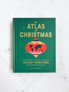 the atlas of christmas book on a marble surface