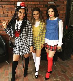 three girls dressed up in costumes posing for the camera