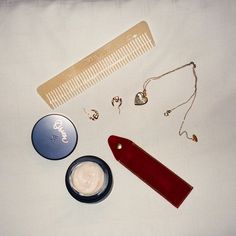 the contents of a hairbrush, comb, and other items laid out on a bed