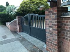 a brick wall and gate in front of a house