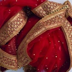 red and gold bridal gown on display in front of a white background with an intricate design