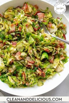 a white bowl filled with chopped lettuce and bacon on top of a table