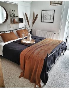 a bedroom with a bed, mirror and other items on the table in front of it