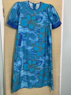 "This vintage 1970's BooBae High Fashion brand custom Hawaiian Lounge dress.  The cotton batik fabric is a vibrant turquoise, royal blue, and gold floral design on a blue and white batik background.  This classic lounge dress has royal blue piping around the neckline and a cuff creating a slightly puffy half sleeve.  Two stylish inset pockets with royal blue details highlight the design on the front of this dress.  There is a back zipper closure.    Sale: $30 Was: $45 Size: No size tag but based on the measurements it is a medium size 12/14.  Check the measurements below as vintage sizing runs smaller than today's clothing.  Condition:  vintage good.  Rare fabric with minor stain on back left side.  Not obvious as it blends into the batik design.  The garment is laundered and ready to wear Blue Retro Cotton Dresses, Retro Blue Cotton Dresses, Blue Hawaiian Printed Dresses, Vintage Blue Printed Dress, Blue Retro Dress With Retro Print, Blue Fitted Hawaiian Dress, Blue Retro Dress With Vintage Print, Blue Batik Print Cotton Dress, Blue Cotton Batik Print Dress