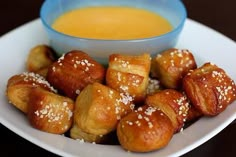 a white plate topped with croissants next to a bowl of orange soup