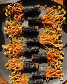 some food is laying out on a black plate and ready to be eaten with chopsticks