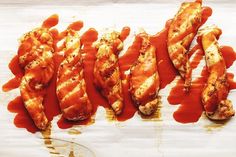 four pieces of chicken covered in ketchup and sauce