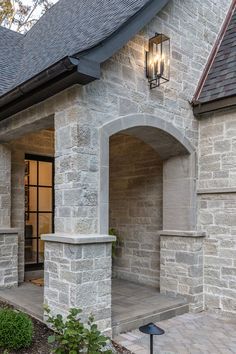 the front entrance to a house with stone walls and arched doorways on either side