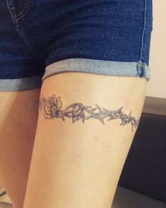 a woman's leg with a tattoo on it that has vines and flowers growing out of it