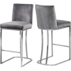 pair of grey velvet bar stools with stainless steel frame base and footrests