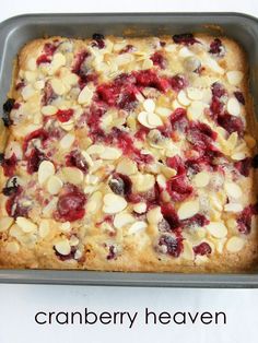 a pan filled with cranberry and almond dessert cake on top of a white table