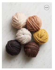 four skeins of yarn on a marble surface