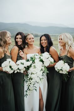 a group of women standing next to each other holding bouquets