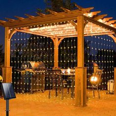 an outdoor gazebo with string lights on it and a grill in the back ground