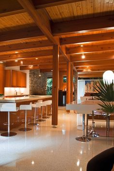 an open kitchen and living room with wooden ceilings