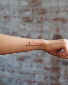 a person's arm with a small tattoo on the left side of their arm