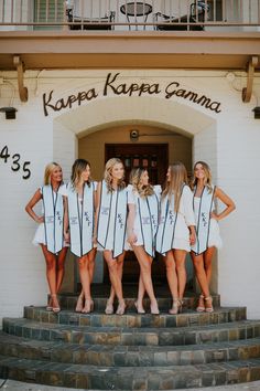 four women in white dresses standing on steps outside a building with the words kora kapa camera written on them