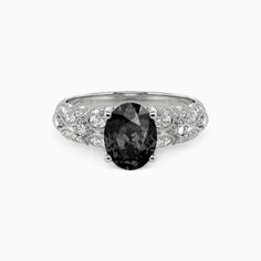 a black and white diamond ring with diamonds around the band, set in 18k white gold