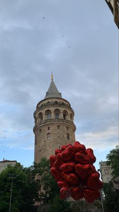 red balloons are in front of a tall tower