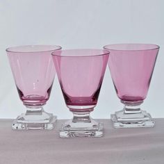 three pink glasses sitting on top of each other