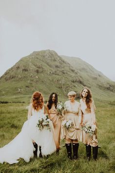 a group of women standing next to each other on top of a lush green field