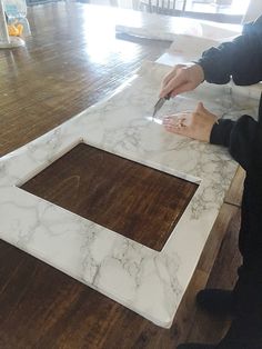 a person cutting up some white marble on a table