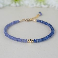 This delicate dainty bracelet combines blue Kyanite and purplish-blue Tanzanite gemstones with 14K yellow gold-filled beads for a serene look. Known for fostering tranquillity and inner strength, this piece is perfect for adding a touch of calm sophistication to any outfit. ⧫  S I Z E  - Length: 6.9in (17.5cm) extendable to 7.9in (20cm) - Width: 4mm ⧫  Y O U   W I L L   R E C E I V E - A beautifully designed branded box, perfect for gifting - Your bracelet - Handwritten thank you card with care instructions - A small pouch for proper storage - A small polishing cloth ♻ All of my packaging materials are eco-friendly and plastic-free. ⧫  W H A T   I S   G O L D   F I L L E D ? Gold-filled jewellery offers an affordable alternative to solid karat gold, made by bonding a layer of solid 14k gol Tanzanite Bracelet, Dainty Bracelet, Small Pouch, Tanzanite Gemstone, Blue Tanzanite, Blue Kyanite, Dainty Bracelets, Small Pouches, Inner Strength