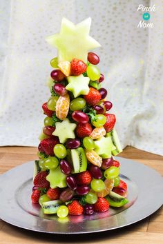 a christmas tree made out of fruit on a plate