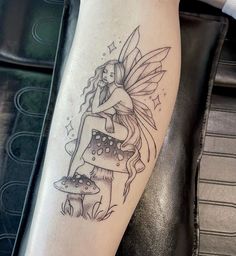 a tattoo with a fairy sitting on top of a mushroom