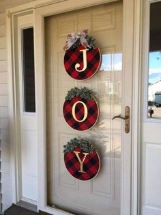 the front door is decorated with plaid wreaths and letters that spell joy, joy