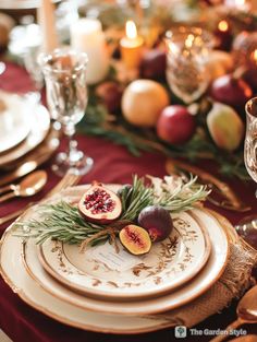 the table is set with plates, silverware and fruit on it for a festive dinner