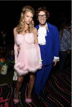 two people dressed in costumes standing next to each other on a carpeted floor at an event