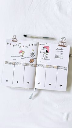 an open planner with stickers on it next to a pen