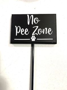 a sign that says no pee zone with a paw print on the front and bottom