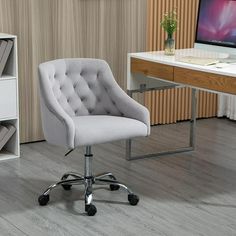 an office chair in front of a desk with a computer monitor and bookshelf