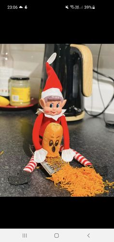 an elf is sitting on the counter next to some noodles and a skull in front of him