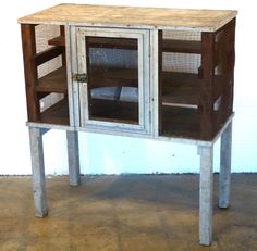 a wooden cabinet with glass doors and metal legs